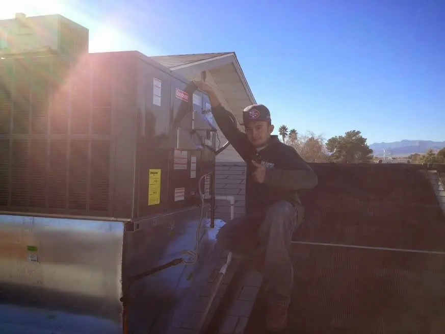 HVAC technician performing AC Tune-Up on a rooftop unit in Poquoson